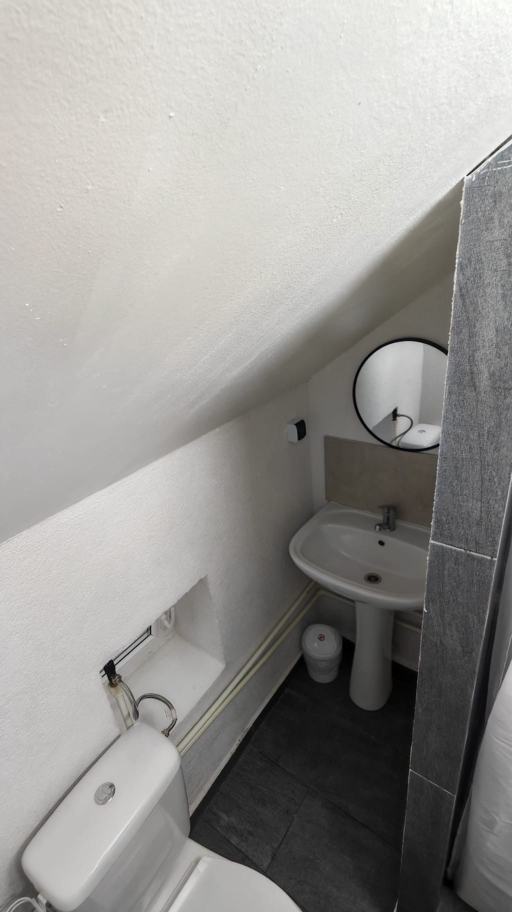 Baie la mansarda cu chiuveta si oglinda rotunda la Radel House Costinesti