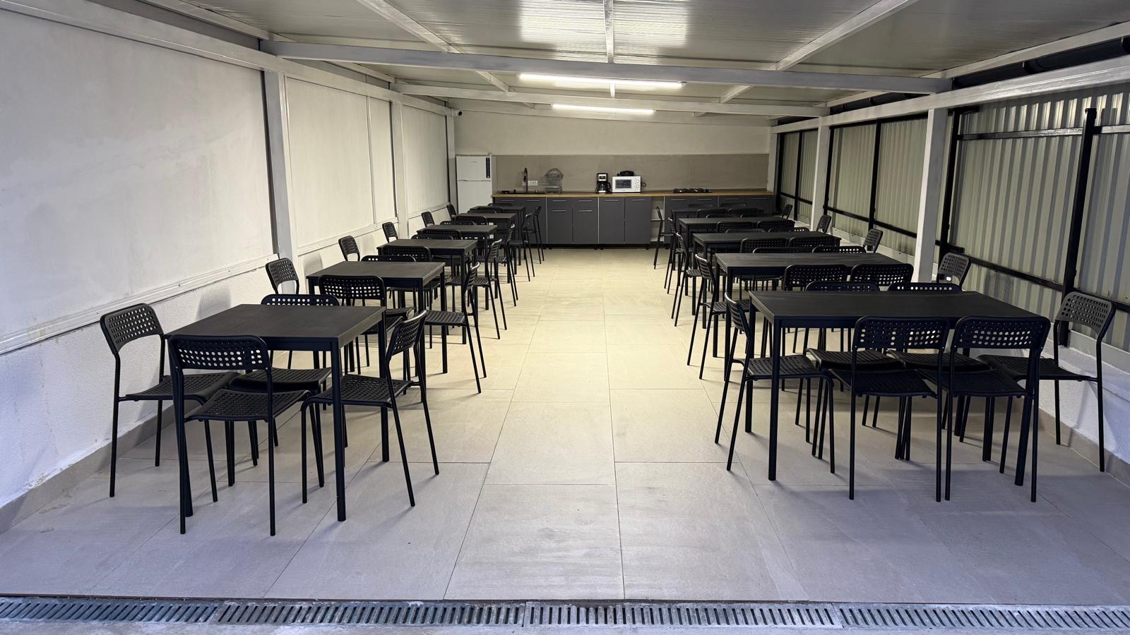 Zona de dining cu mese si scaune in foisorul Radel House Costinesti
