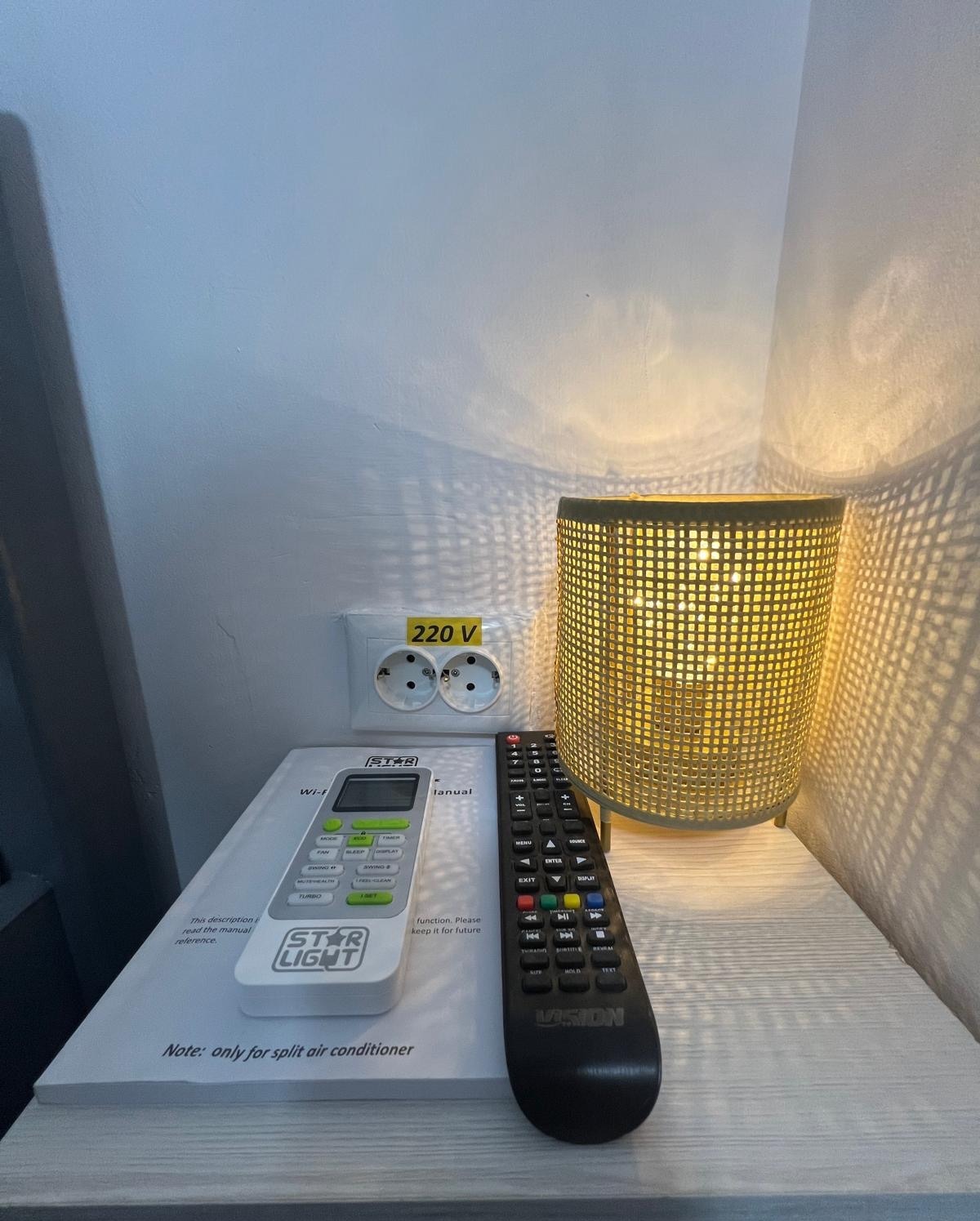 Detaliu noptiera cu lampa si telecomanda in camera de la Radel House Costinesti