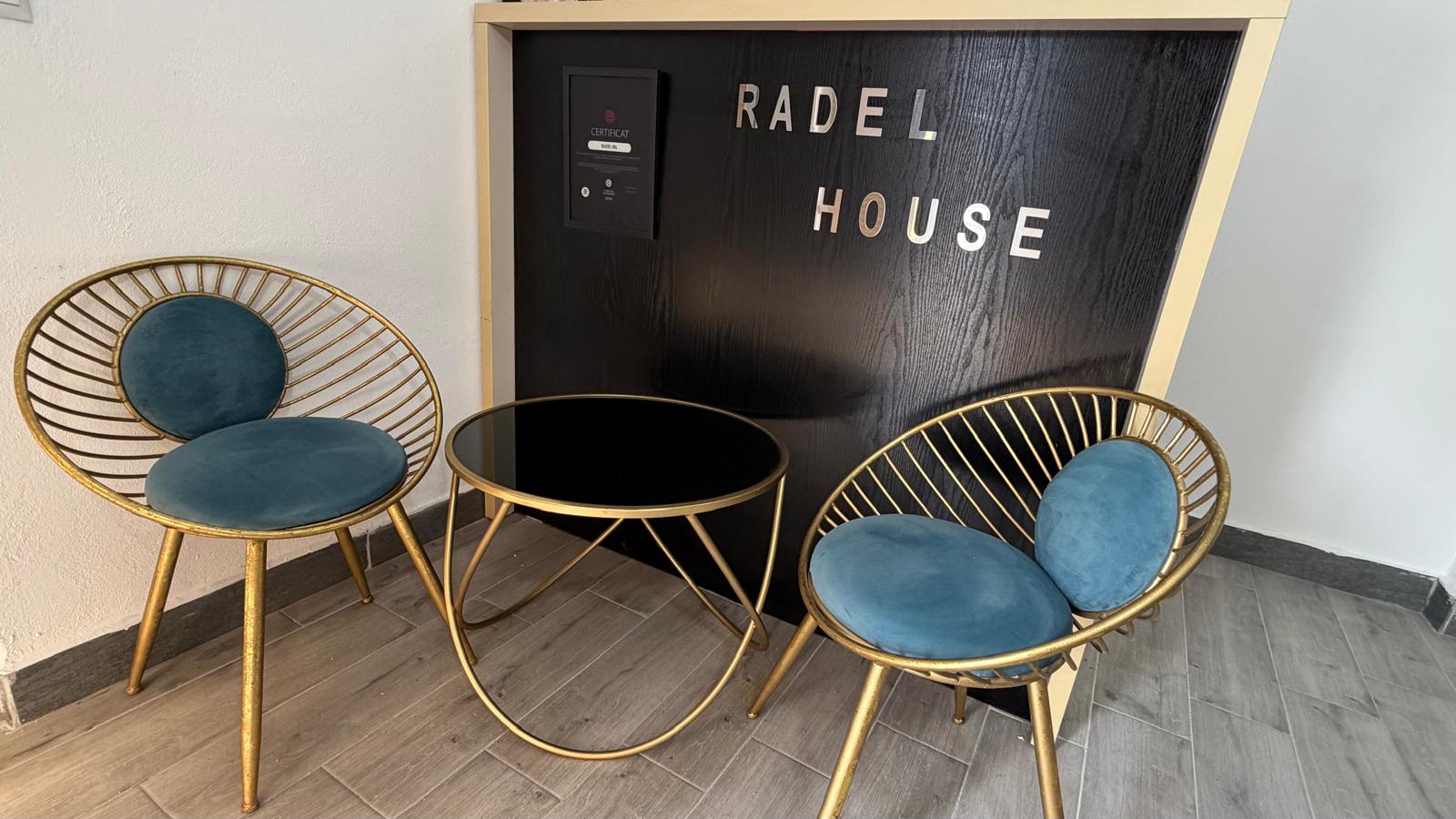 Coltarul zonei de asteptare cu fotolii aurii si masa de cafea — intrare Radel House