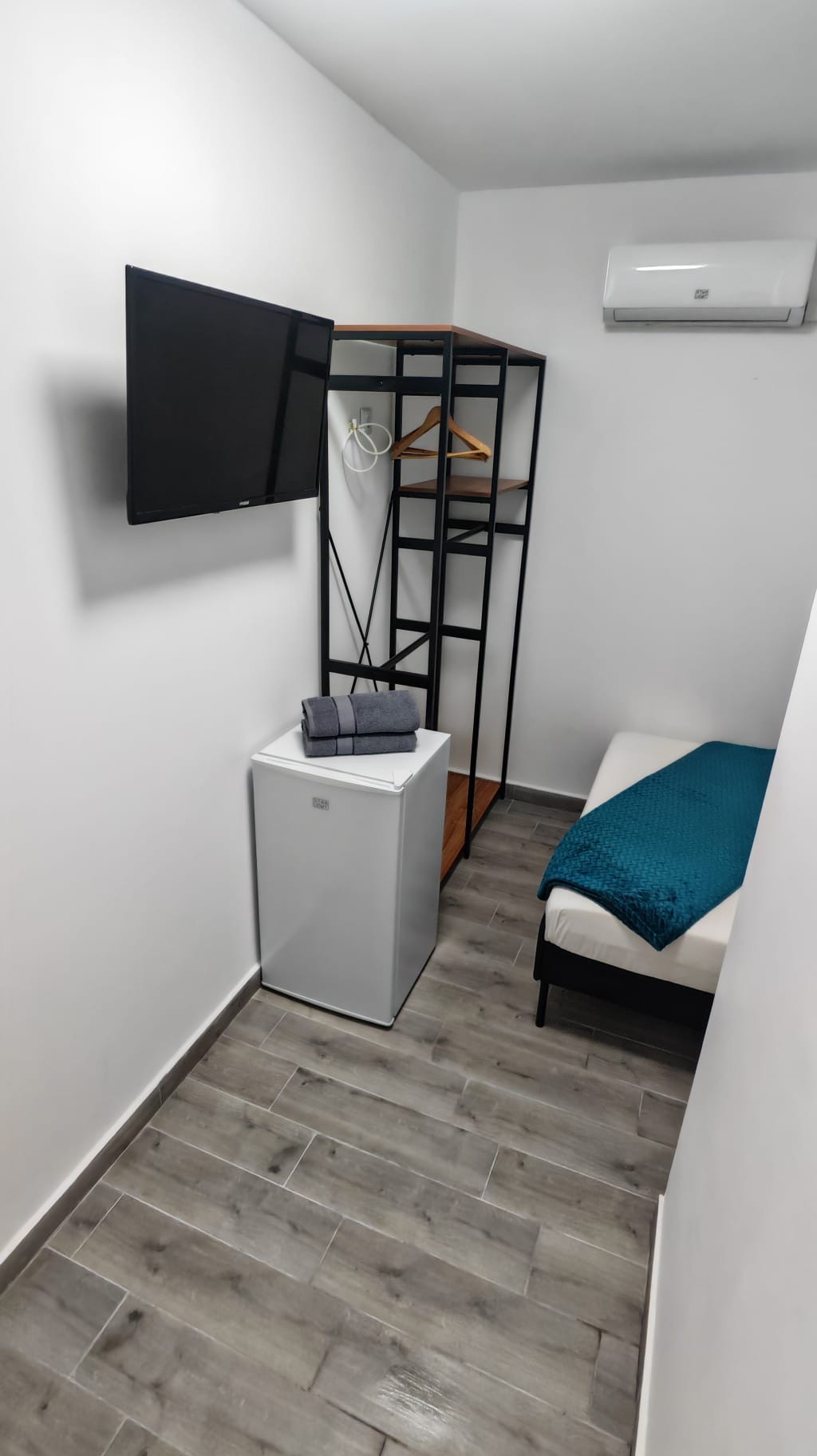 Camera moderna cu TV, frigider si dulap deschis la Radel House Costinesti